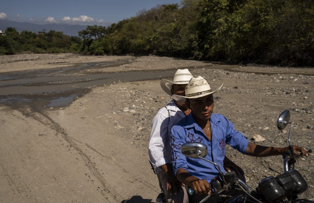 Dos hombres pasean en motocicleta en un río seco en el Corredor Seco de Guatemala. Foto: Oliver de Ros