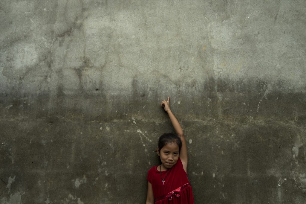 Niña de la aldea San Jorge muestra hasta dónde llegó el agua durante la inundación de noviembre de 2023. Foto: Oliver de Ros.