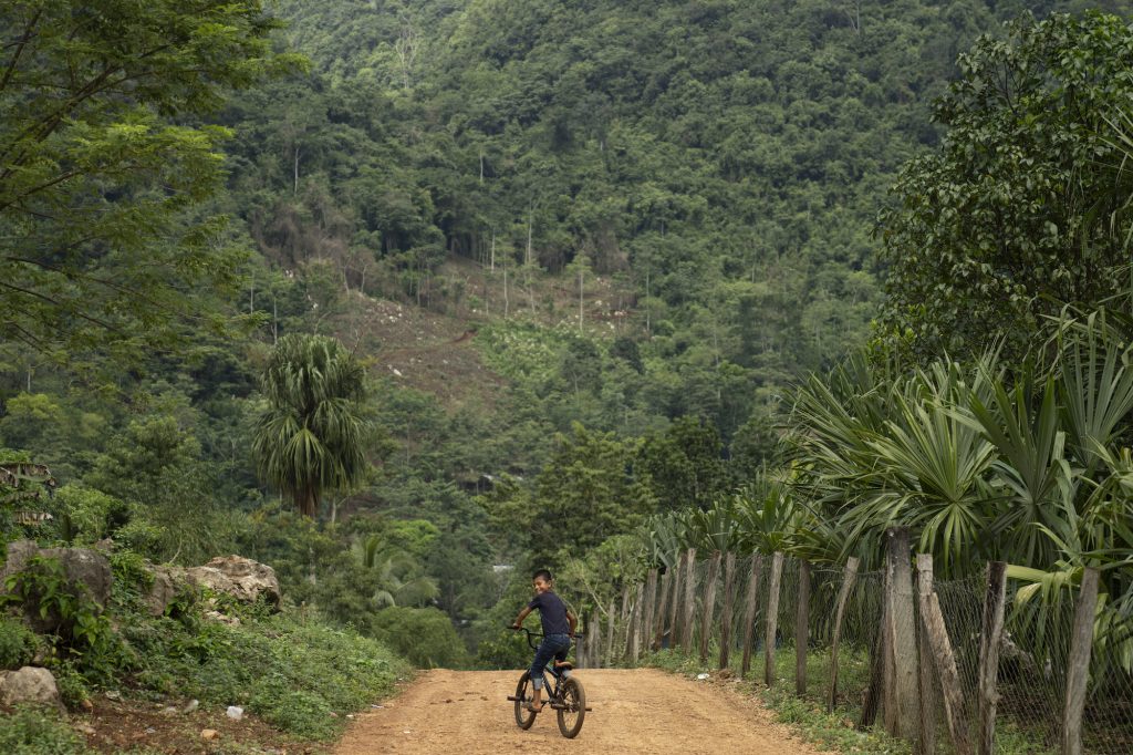 Un niño pedalea su bicileta en una aldea de Raxruhá, Alta Verapaz. Foto: Oliver de Ros.