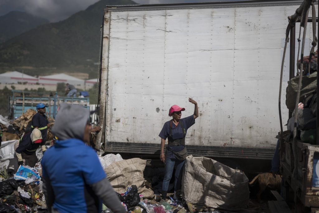 Tania Paul de 42 años ayuda a guiar un camión con desechos previo a ser descargado por ella y los demás recolectores. Foto: Edwin Bercián