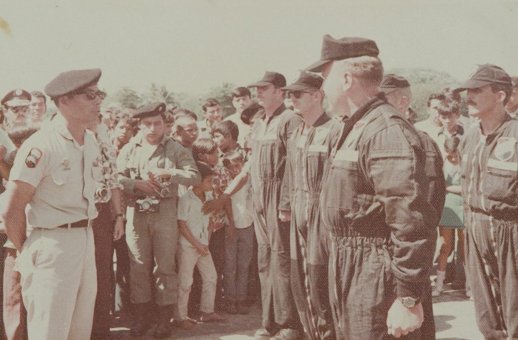 Un grupo de aviadores estadounidenses escucha el discurso de Benedicto en la Base Militar de Tropas Paracaidistas ubicada en el Puerto de San José, Escuintla, durante la primera mitad de los 70. (Del documental El buen cristiano) 