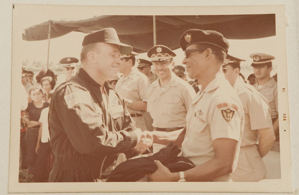 Benedicto, el entonces presidente de la república Kjell Eugenio Laugerud García y un oficial estadounidense sonríen durante un acto en la Base Militar de Tropas Paracaidistas, en el Puerto de San José. (Del documental El buen cristiano)