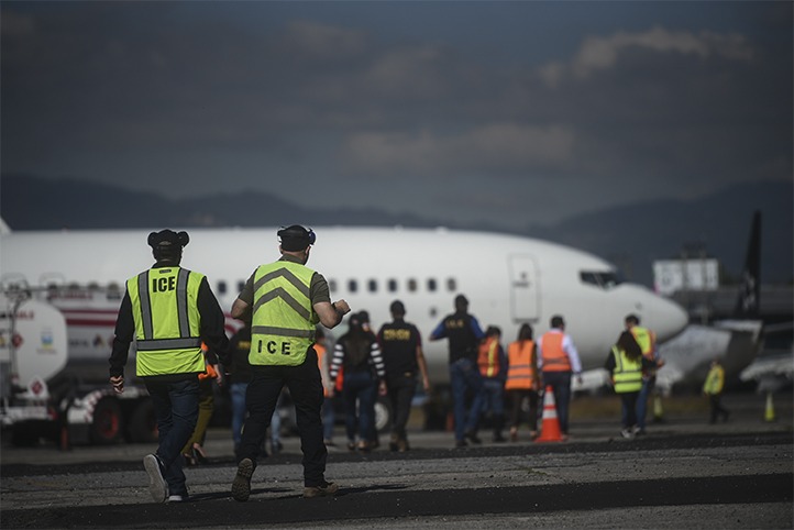 Integrantes del Servicio de Inmigración y Control de Aduanas (ICE, por sus siglas en inglés) supervisan el retorno de decenas de migrantes el 29 de diciembre de 2022 en la Fuerza Aérea Guatemalteca