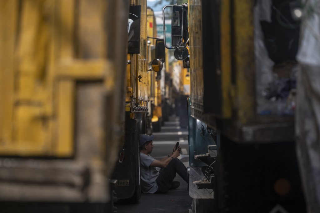 Un recolector observa su celular en medio de los camiones que bloquean los alrededores del Ministerio de Ambiente, durante una jornada de protesta que duró más de diez horas. Foto/Edwin Bercián