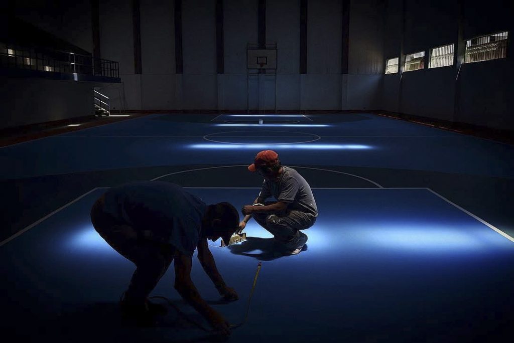 Dos trabajadores remozan una cancha deportiva el 30 de julio de 2018. Foto/Edwin Bercián.