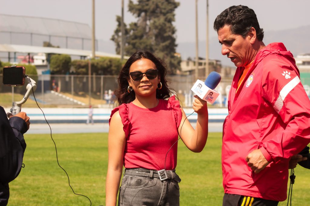 Andrea entrevista al entrenador Javier antes del entrenamiento del equipo, previo al primer partido de la nueva jornada del Xelajú MC. Foto: Catarina Huix