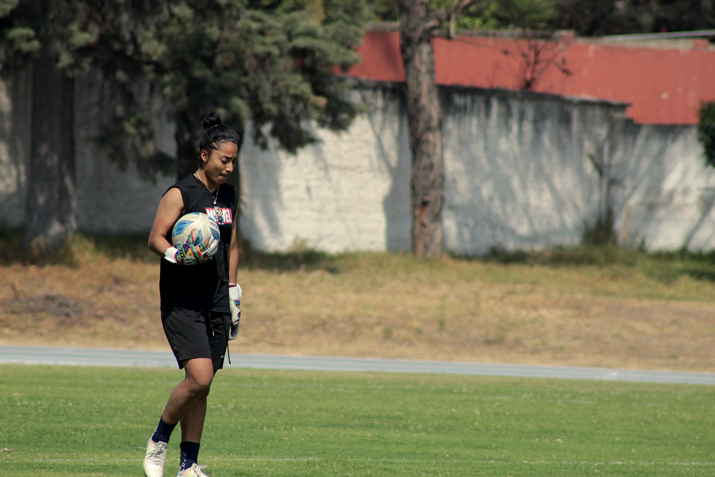 Anayeli Quintanilla, del equipo femenino Xelajú MC,  toma el balón mientras avanza para recibir indicaciones de su entrenador antes de iniciar el entrenamiento. Foto: Catarina Huix