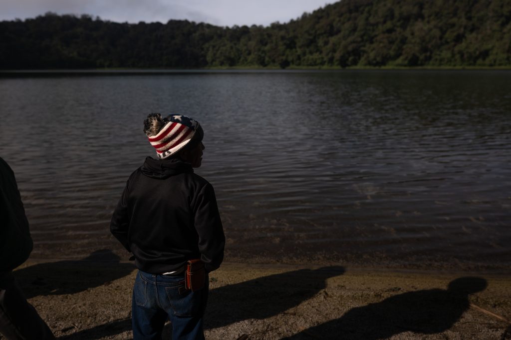 Una persona observa el agua de la Laguna Chicabal, mientras en voz baja reza por la lluvia. Foto/Edwin Bercián