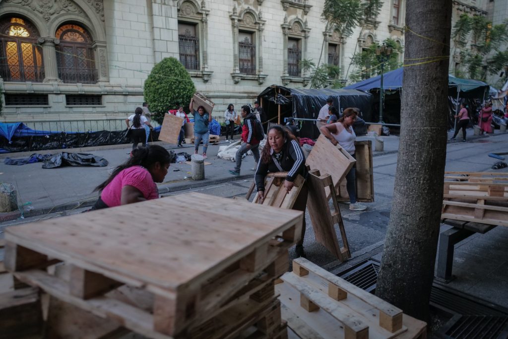 Un vendedor de pinturas camina junto a decenas de elementos antimotines durante el desalojo de integrantes del STEG.