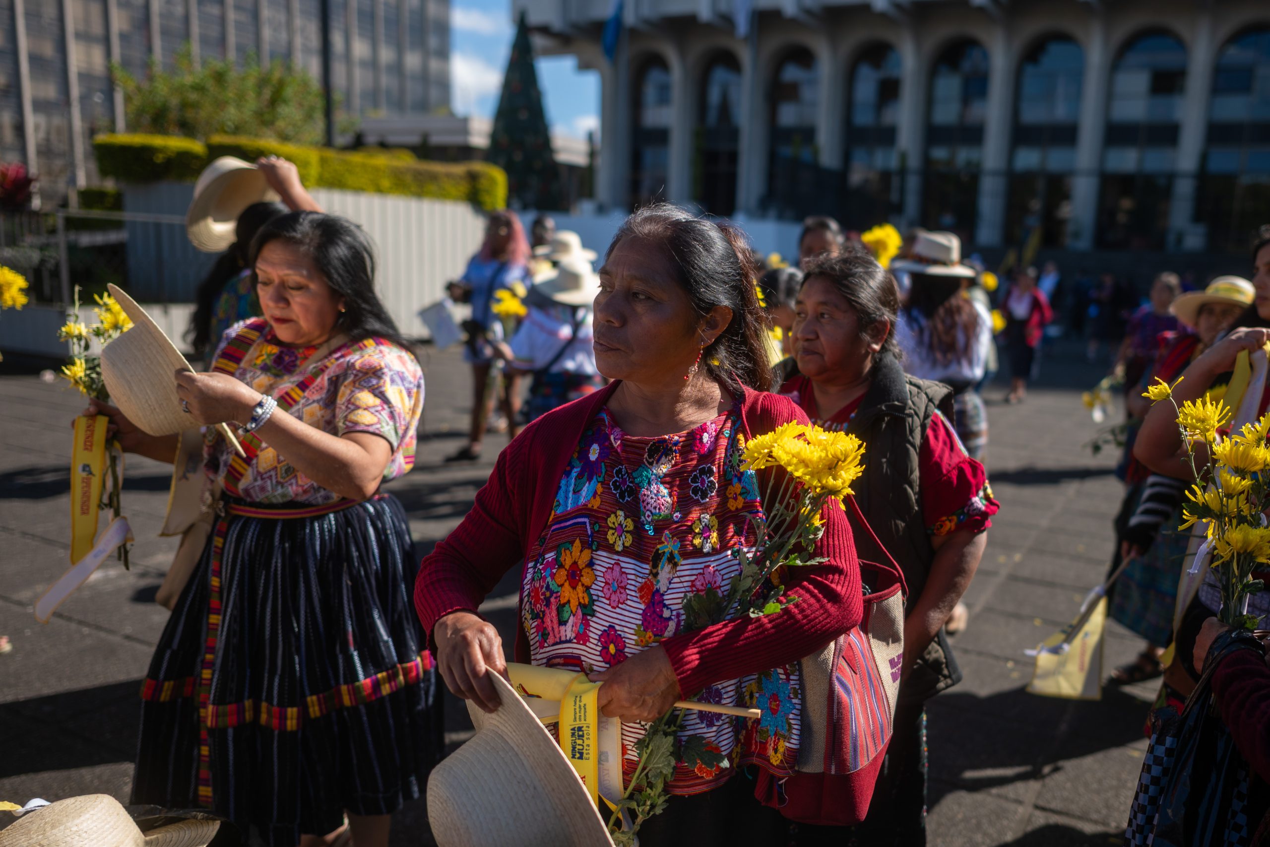 Mujeres indígenas participan en una caminata con flores amarillas frente a la Corte Suprema de Justicia, durante una jornada de memoria y exigencia de justicia por la violencia en contra de las mujeres, durante el Día Internacional de la Eliminación de la Violencia contra la Mujer. Foto/Edwin Bercián