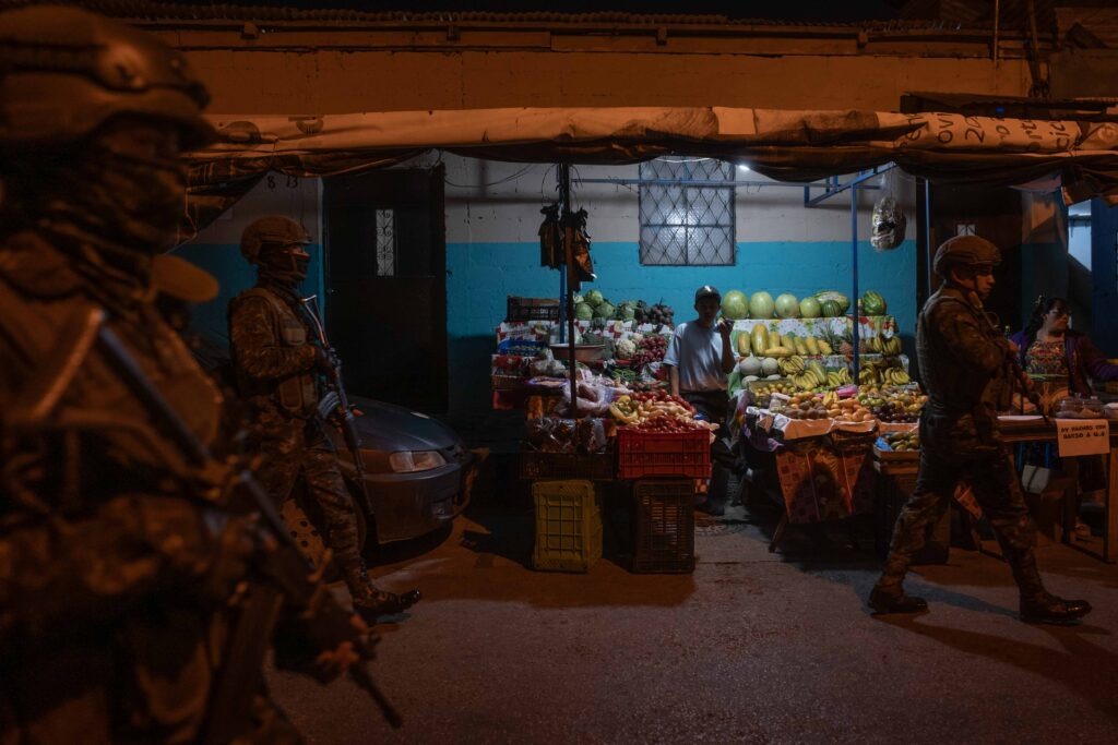 Un vendedor de frutas observa la presencia de soldados del ejército durante un recorrido realizado en el barrio El Gallito. Foto/Edwin Bercián