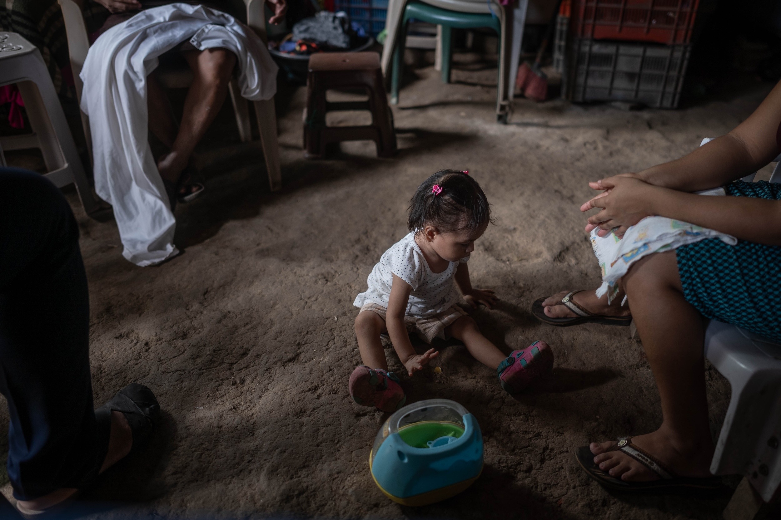 Britney Isabel Alvarado de un año, juega sobre el piso de tierra a un lado de su madre en el municipio de San Felipe, Retalhuleu. Foto/Edwin Bercián