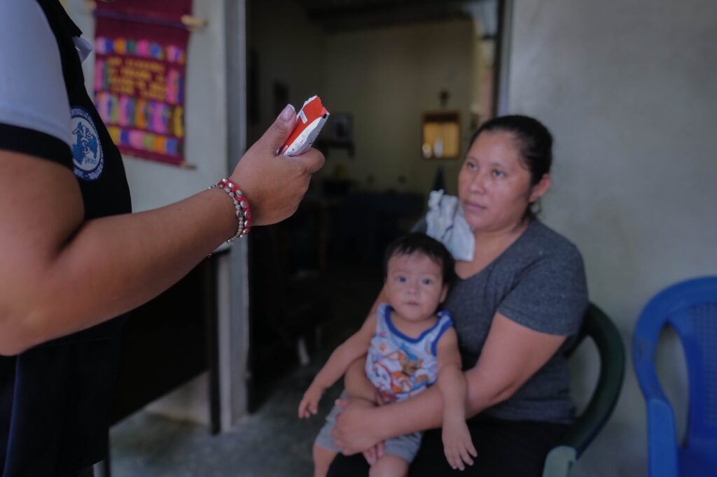 La nutricionista Mishel Loarca entrega alimentos terapéuticos a Janet Carmina Juárez durante una visita de control de salud. Foto/Edwin Bercián