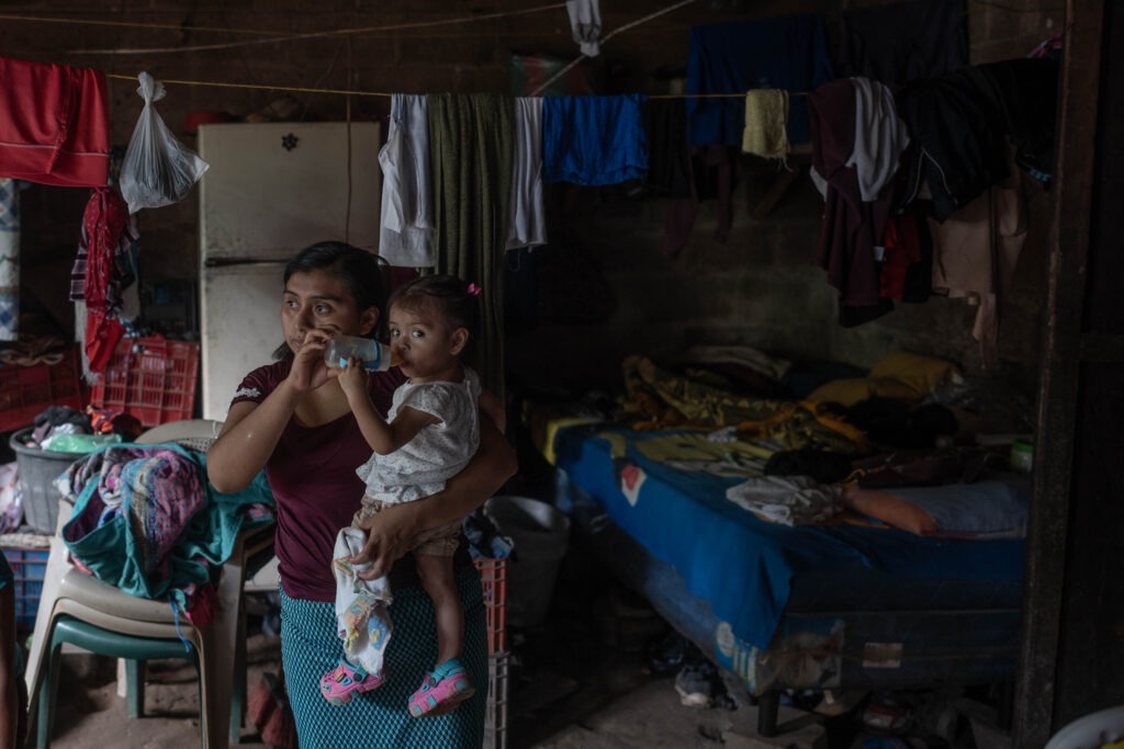 María Isabel Alvarado carga en sus brazos a su hija Britney Alvarado mientras toma leche de un biberón. Foto/Edwin Bercián