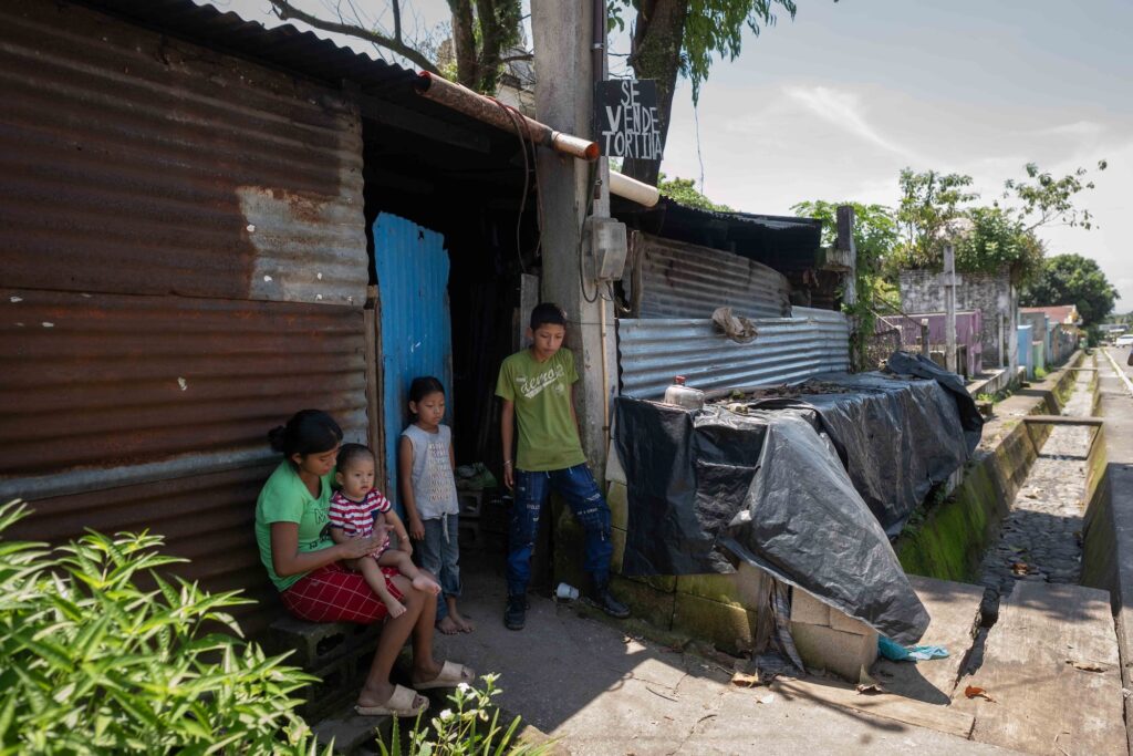 Ruth Morales permanece sentada en la entrada de su hogar junto a su hijo José Eduardo y los sobrinos de su esposo a quienes debe cuidar. Foto: Edwin Bercián