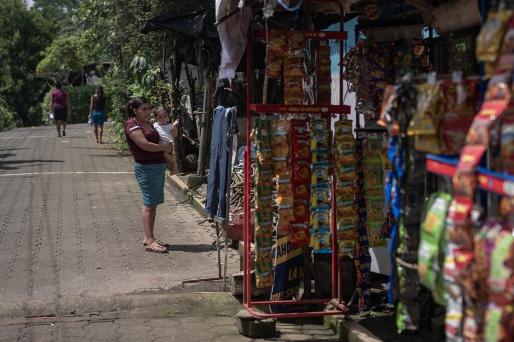 María Isabel Martínez sostiene en brazos a su hija frente a su casa en el municipio de San Felipe en Retalhuleu. Foto: Edwin Bercián