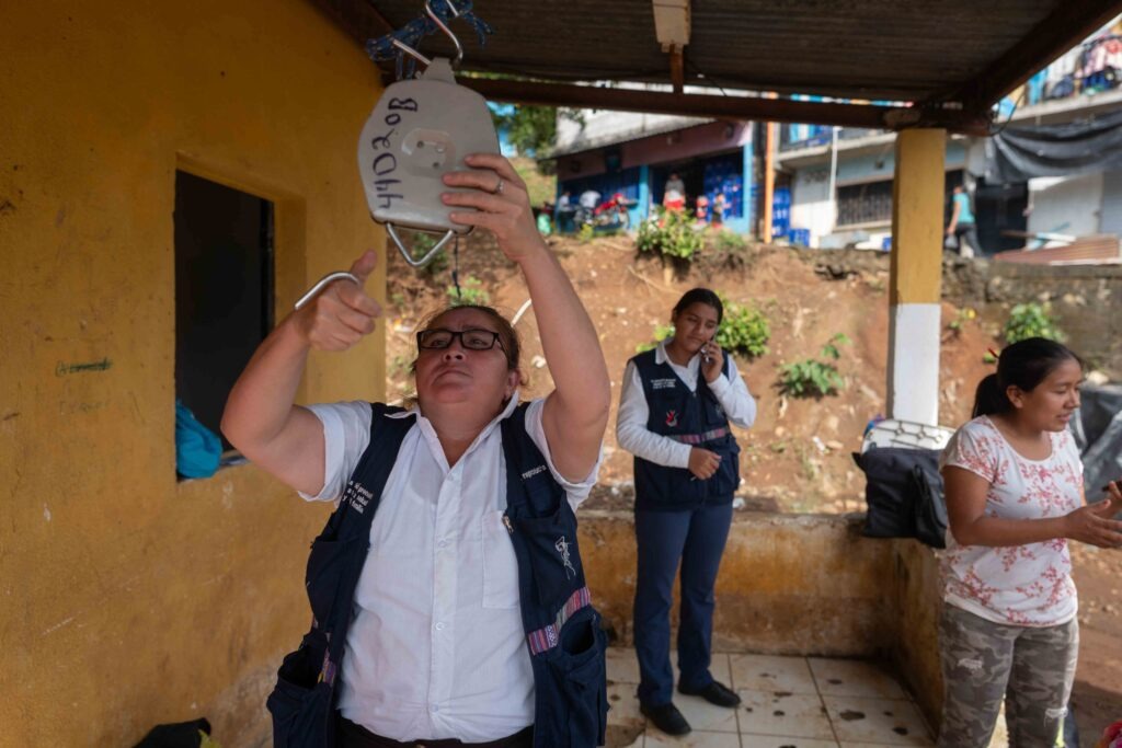 La auxiliar de enfermería, Maura Verónica, prepara la báscula para pesar a menores durante una jornada de salud y nutrición en la comunidad Lucerna en Escuintla. Foto/Edwin Bercián