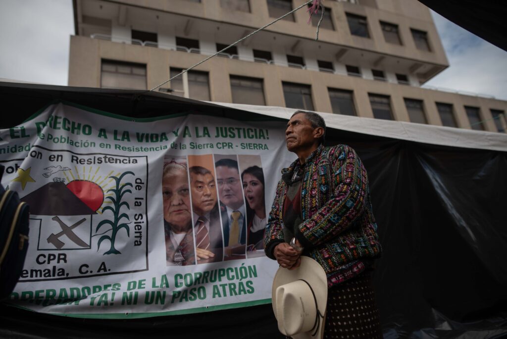 Un integrante de las autoridades ancestrales observa el edificio del Ministerio Público durante las protestas del paro nacional, convocado por líderes indígenas ante las acciones en contra del proceso electoral el 14 de noviembre de 2023. Foto/Edwin Bercián