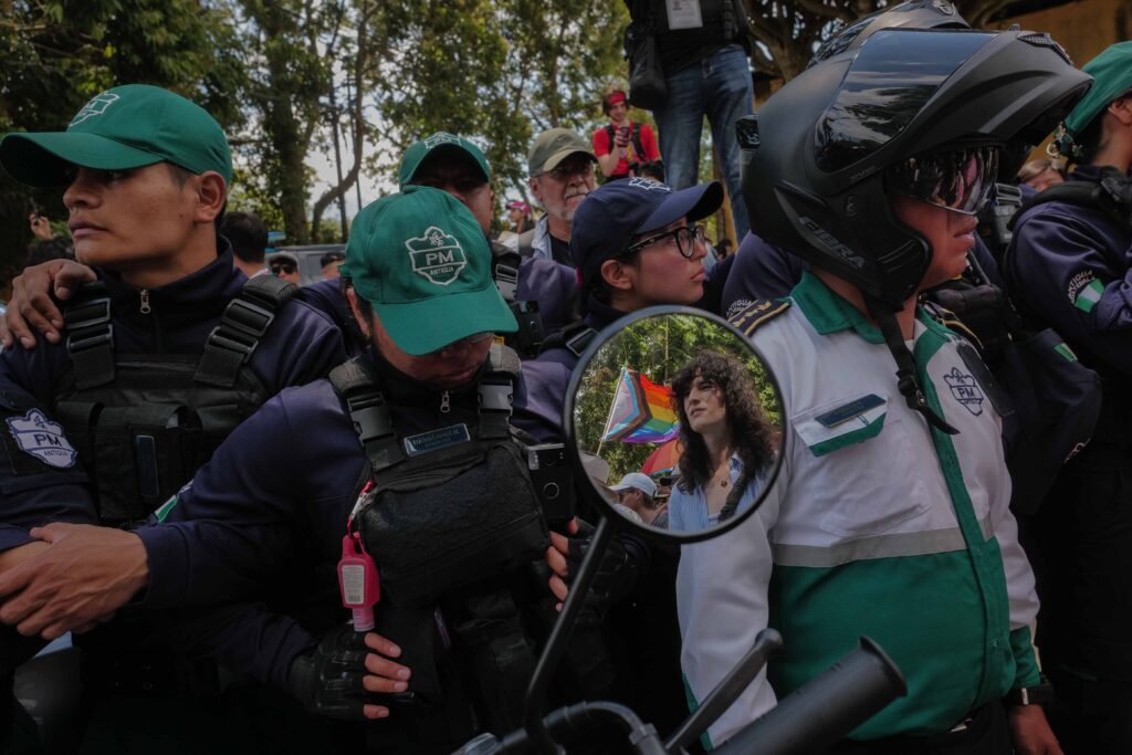 Agentes de la Policía Municipal bloquean una de la entradas principales hacia el casco urbano de Antigua Guatemala, mientras decenas de personas que acompañan la marcha muestran su inconformidad ante las restricciones. Foto/Edwin Bercián