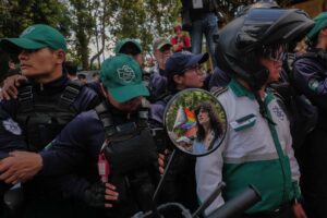 Agentes de la Policía Municipal bloquean una de la entradas principales hacia el casco urbano de Antigua Guatemala, mientras decenas de personas que acompañan la marcha muestran su inconformidad ante las restricciones. Foto/Edwin Bercián
