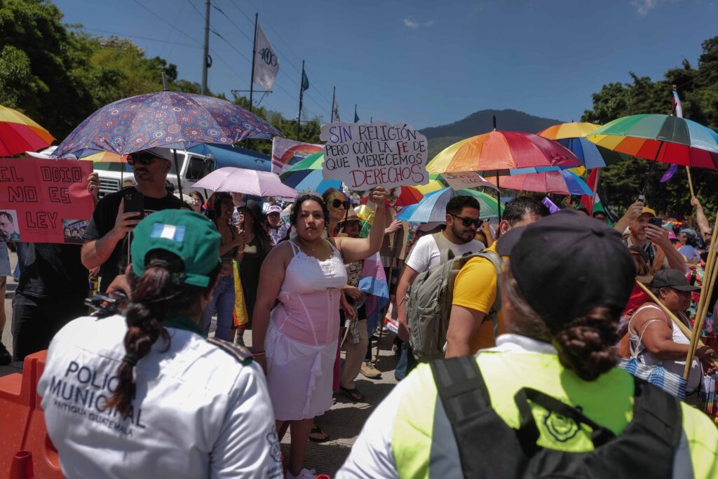 Agentes de la Policía Municipal bloquean una de la entradas principales hacia el casco urbano de Antigua Guatemala, mientras decenas de personas que acompañan la marcha muestran su inconformidad ante las restricciones. Foto/Edwin Bercián
