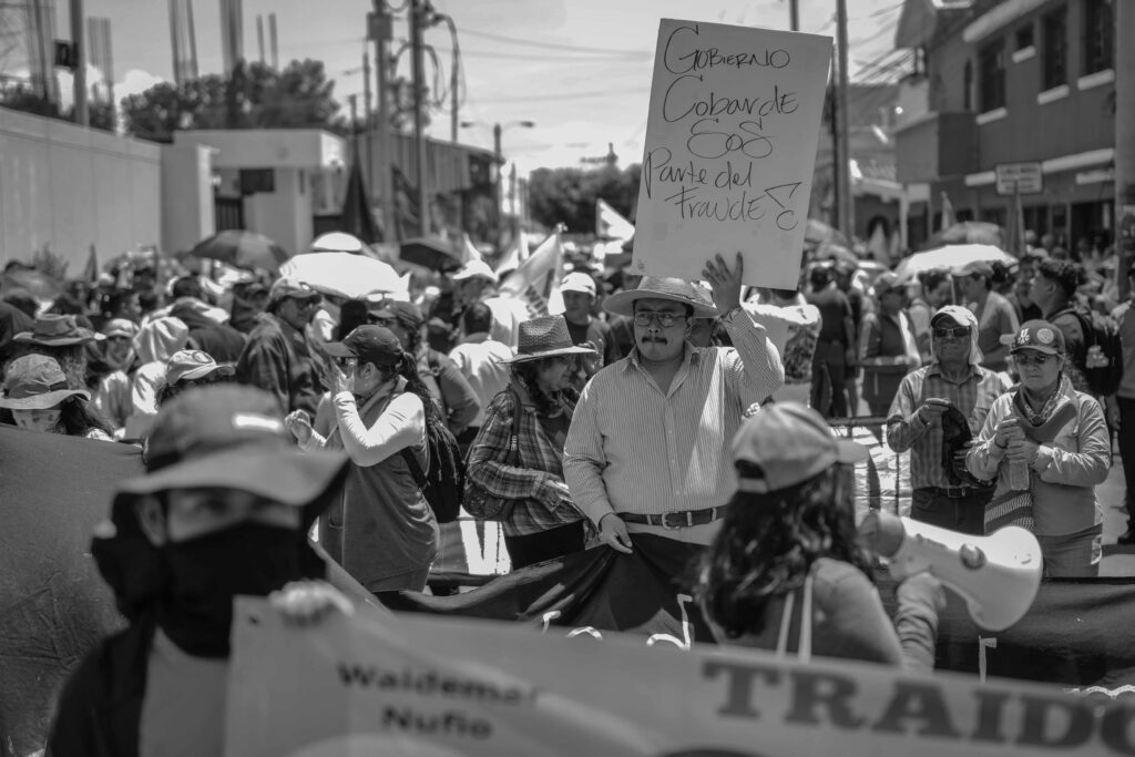 Un manifestante sostiene un cartel durante la marcha convocada por el movimiento USAC-DIRE este domingo en la Ciudad de Guatemala. La movilización rechazó la reelección de Walter Mazariegos como rector de la Universidad de San Carlos (Usac), al considerar que el proceso estuvo marcado por irregularidades y fraude, y exigió que la Corte de Constitucionalidad resuelva las acciones legales relacionadas con la elección. Foto/Edwin Bercián