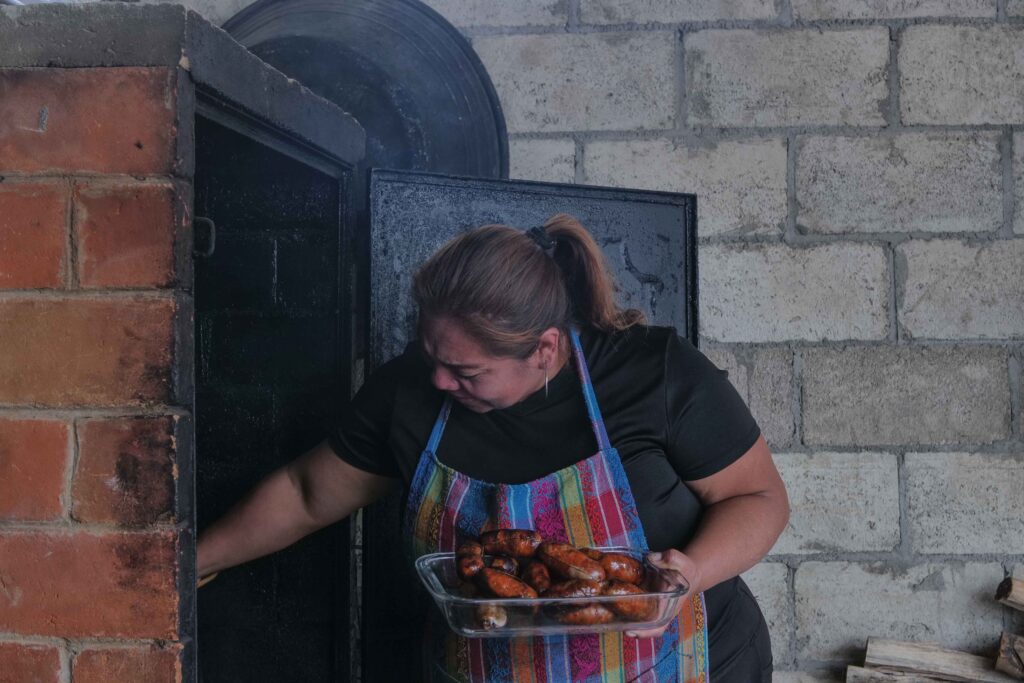 Marta Lucía extrae unos chorizos y longanizas recién horneados y que venderá como parte de su emprendimiento. Foto: Edwin Bercián.