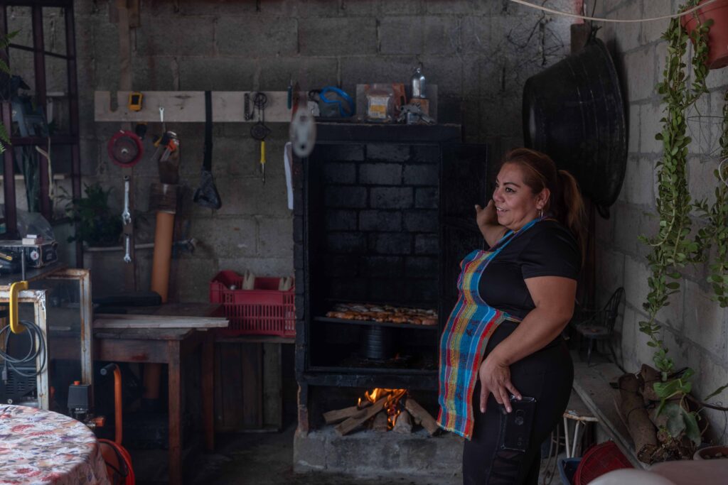Marta Lucía Hernández, migrante retornada, muestra su emprendimiento de ahumados artesanales en Quetzaltenango.