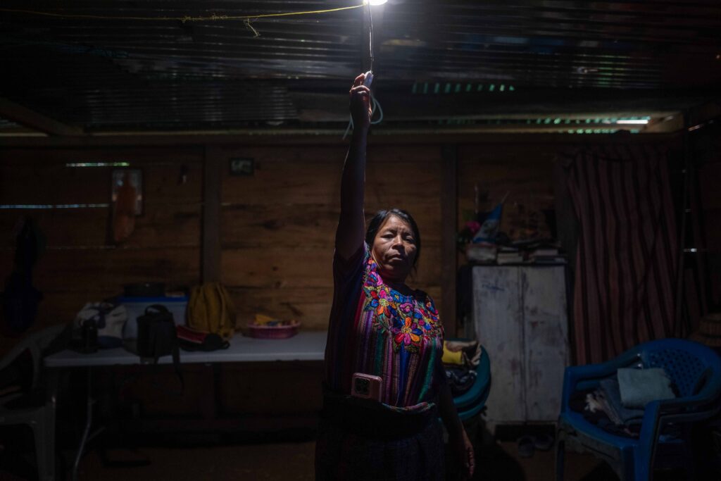 Catarina Rodríguez Aguilar enciende una de las bombillas alimentadas por el sistema de energía solar instalado en su vivienda, en la comunidad de Vichemal, San Gaspar Chajul, Quiché. Foto/Edwin Bercián