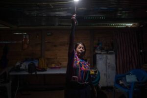 Catarina Rodríguez Aguilar enciende una de las bombillas alimentadas por el sistema de energía solar instalado en su vivienda, en la comunidad de Vichemal, San Gaspar Chajul, Quiché. Foto/Edwin Bercián