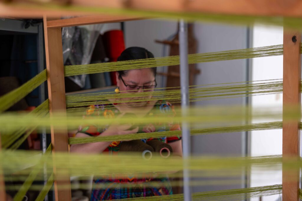 La artista Angélica Serech sostiene algunos conos de hilos durante una entrevista en su estudio, en San Juan Comalapa. Foto/Edwin. Bercián