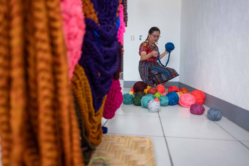 La artista Angelica Serech, muestra algunas madejas de hilos en su estudio ubicado en San Juan Comalapa. Foto/Edwin Bercián