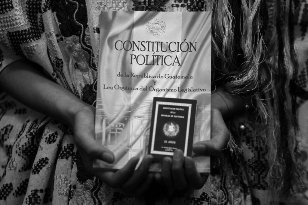 Un ejemplar de la Constitución Política de la República de Guatemala es sostenido por integrantes de pueblos indígenas durante una actividad por el día de la Constitución el 31 de mayo de 2015. Foto/Edwin Bercián