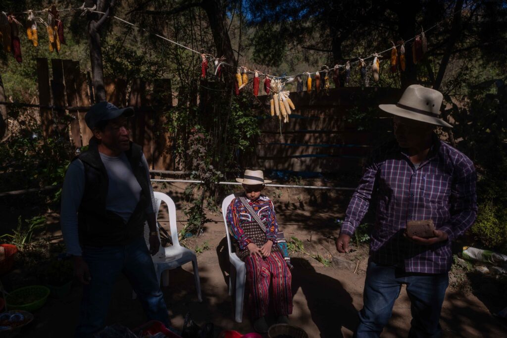 Un niño permanece sentado mientras guías espirituales preparan el área donde se llevaría a cabo una ceremonia por la bendición de semillas en la comunidad de Chaquijyá, en Sololá el 6 de marzo de 2026. Foto/Edwin Bercián