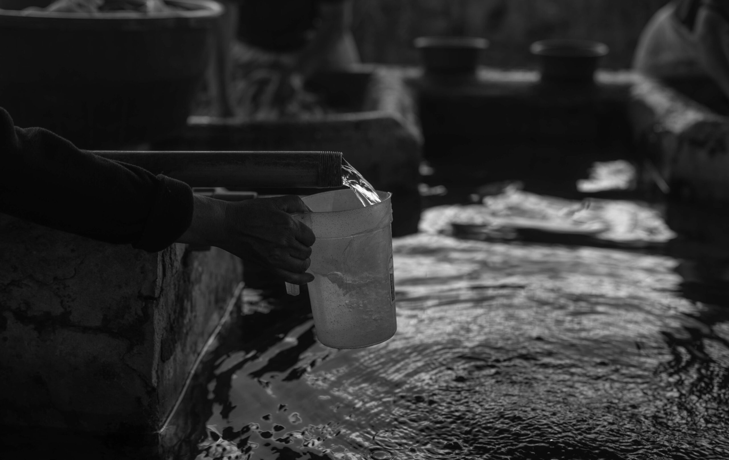 Una persona llena un recipiente con agua en una pila municipal de Quetzaltenango el 31 de julio de 2026. Foto/Edwin Bercián