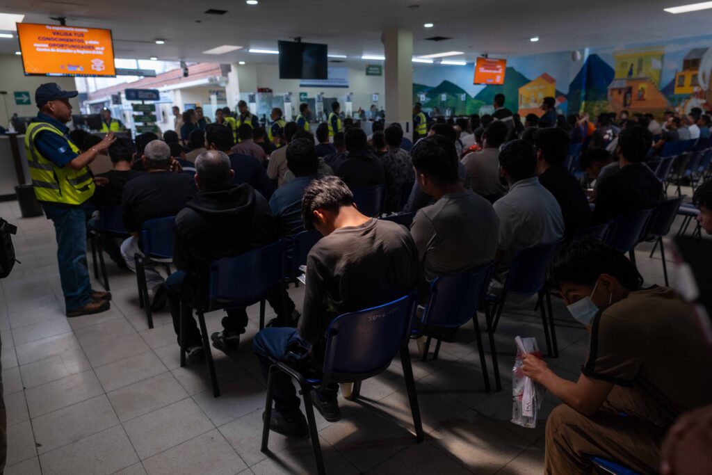 En el Centro de Recepción de Retornados, migrantes retornados esperan instrucciones y recibir sus teléfonos celulares. Foto/Edwin Bercián