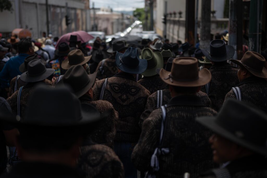 Manifestantes avanzan frente al Congreso de la República con pancartas en rechazo al aumento del precio del combustible.